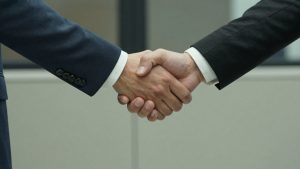 Mâini strângându-se, simbolizând un acord de franciză.